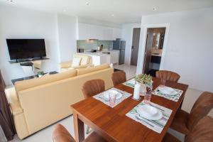 a dining room and living room with a table and chairs at Bangsaray Vacation in Bang Sare