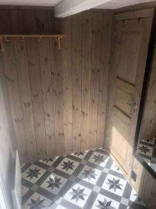 a room with wooden walls and a checkered floor at Unik overnatting i Stabbur/Minihus in Lunde