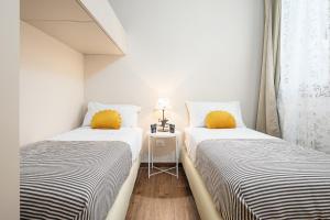2 letti con cuscini gialli in una piccola stanza di Classbnb - Two apartments 500m from the skilifts a Breuil-Cervinia