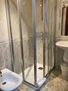 y baño con ducha y lavamanos. en Pensión Residencia Fornos, en Santiago de Compostela
