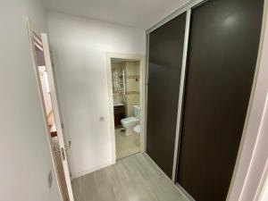 baño con aseo y puerta negra en Apartamento Cuzco en Madrid