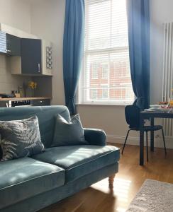 un soggiorno con divano blu e tavolo di Bouverie Bolthole a Folkestone