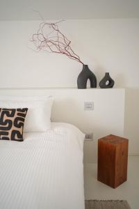 a bedroom with a white bed with a vase on top of it at Parisina Design Rooms in Pescara