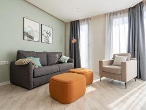 ein Wohnzimmer mit einem Sofa und einem Stuhl in der Unterkunft limehome Barcelona Rector Triadó in Barcelona