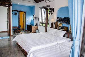 um quarto com uma grande cama branca e uma secretária em La Y Riverview em Hue