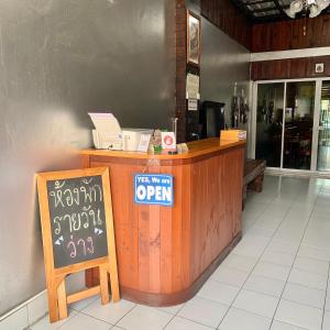 a restaurant counter with a sign that says potential open at PD Hostel in Ban Don Muang
