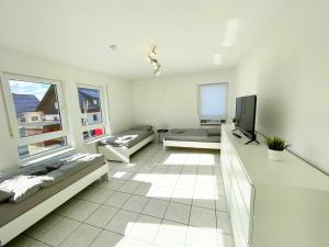 a white living room with a tv and a couch at Nice 2,5-Room Apartment in Untergruppenbach