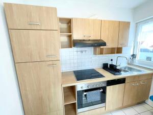 a kitchen with wooden cabinets and a stove top oven at Nice 2,5-Room Apartment in Untergruppenbach