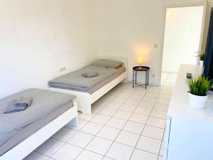 a bedroom with two beds and a table with a lamp at Nice 2,5-Room Apartment in Untergruppenbach