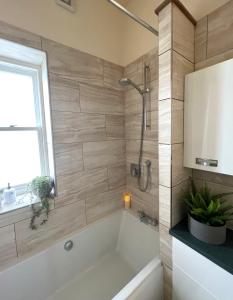 a bathroom with a bath tub and a window at Bouverie Bolthole in Folkestone