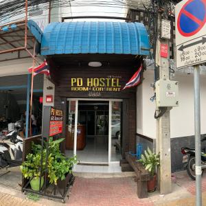 un edificio con una casa de pdq con un cartel en ella en PD Hostel en Ban Don Muang