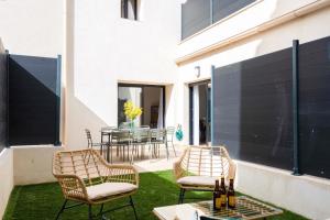 a patio with two chairs and a table with wine bottles at MaisonMars - La Maison du Parc 3 - Terrasse Parking in Marseille
