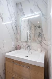 uma casa de banho branca com um lavatório e um espelho em MaisonMars - La Maison du Parc 3 - Terrasse Parking em Marselha