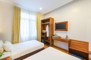 pokój hotelowy z łóżkiem i telewizorem w obiekcie Nature Hotel w mieście Da Lat