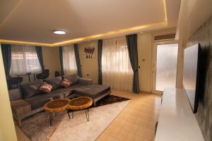 - un salon avec un canapé et deux tables dans l'établissement Olori Rentals, à Kampala