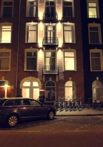 ein Auto, das vor einem Gebäude geparkt ist, mit Fahrrädern, die vorne geparkt sind in der Unterkunft Sara's Boutique Hotel in Amsterdam
