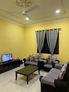 a living room with couches and a flat screen tv at IJW HOMESTAY in Kuala Terengganu