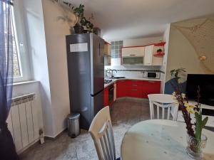 a kitchen with a refrigerator and a table with chairs at Apartment Terassin in Koper