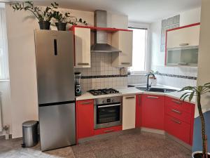 a kitchen with red cabinets and a refrigerator at Apartment Terassin in Koper