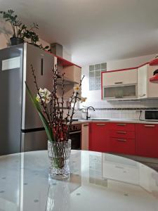 a vase with flowers on a table in a kitchen at Apartment Terassin in Koper