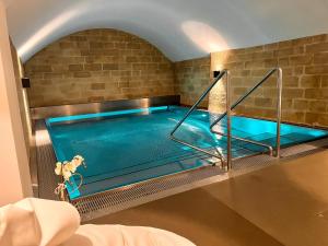 an indoor swimming pool with blue water in a room at Moderne Altbauwohnung mit Pool und Sauna in Bern