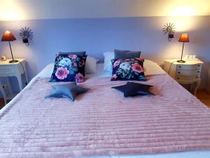 un grande letto bianco con cuscini sopra di B&B Caprice d'Epices a Francorchamps