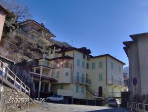un bâtiment sur une colline avec des voitures garées devant lui dans l'établissement MAGICAL HOUSE ON THE LAKE OF COMO, à Bellano