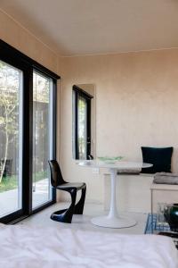 a table and a chair in a room with a window at Containerhus 18b in Harboør