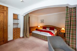1 dormitorio con 1 cama y 1 silla en una habitación en Sporthotel Teresa, en Badia