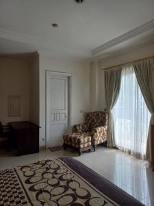een woonkamer met een stoel en een raam bij Margot Apartment Pondok Indah in Jakarta