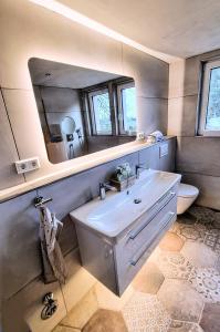 uma casa de banho com um lavatório branco e um espelho. em Exklusives Holzhaus mit Bergbahn - Baden-Baden im Schwarzwald em Baden-Baden