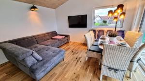 ein Wohnzimmer mit einem Sofa und einem Tisch in der Unterkunft Exklusives Holzhaus mit Bergbahn - Baden-Baden im Schwarzwald in Baden-Baden