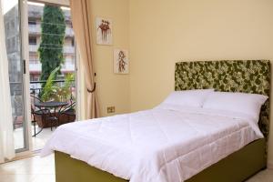 - une chambre avec un lit et un balcon dans l'établissement Olori Rentals, à Kampala
