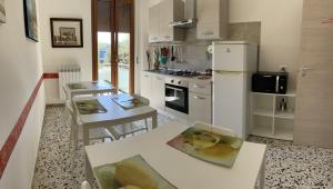 セニガッリアにあるCASA VACANZE Affittacamere Senigallia 158のテーブルと白い冷蔵庫のあるキッチン