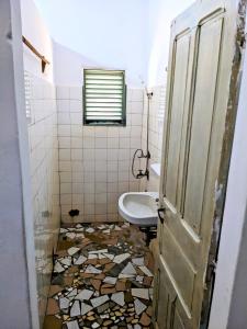 a bathroom with a toilet and a sink at Chambres d'hôtes - Chez Mama Sêdjro in Porto-Novo