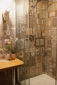 a shower stall in a bathroom with a wooden table at Jēkaba sēta in Kuldīga