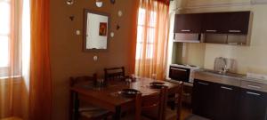 a kitchen with a table and chairs and a kitchen with a counter at Dora's happy apartment in Mantoúkion