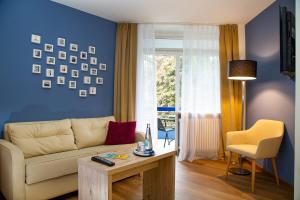 a living room with a couch and a table at Fini-Resort Badenweiler in Badenweiler