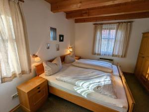 1 cama grande en un dormitorio con 2 ventanas en Waldhaus 46, 48, 49 im Waldferiendorf, en Regen