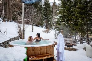 two women in a hot tub in the snow at Sporthotel Teresa in Badia