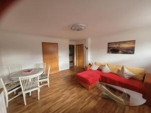 a living room with a red couch and a table at Ferienwohnung Schmidt in Neu Sallenthin