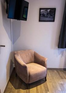 a brown chair sitting in a room with a tv at Beim Hooch "Marie" in Brücktal