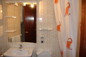 Un baño con lavabo, inodoro y espejo. en Hostal Mengual, en Gandía