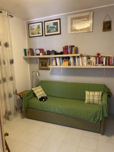 un sofá verde en una sala de estar con libros en Casa nel Parco, en Cassano delle Murge