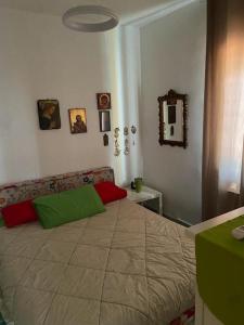 Un dormitorio con una cama grande con almohadas verdes y rojas en Casa nel Parco, en Cassano delle Murge