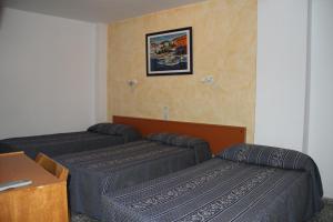 una sala de estar con dos camas y un sofá en Hostal Mengual, en Gandía 12 fotos más