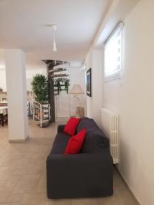 salon z czarną kanapą i czerwonymi poduszkami w obiekcie Seagull Apartments - front and Sea View & Airport Bari w mieście Bari