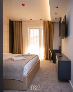 ein Hotelzimmer mit einem Bett und einem Fenster in der Unterkunft Ador Hotel North Mitrovica in Mitrovica