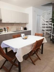 cocina con mesa blanca y sillas en Seagull Apartment - Sea Front & Airport Bari, en Bari