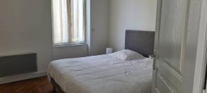 a bedroom with a white bed with a window at Résidence Auger in Bourges